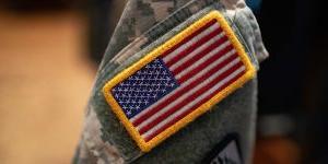 An American flag badge on an army uniform.